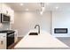 Modern kitchen with stainless steel appliances, white cabinets, island with seating, and a cozy fireplace at 4523 Moray Dr, Mableton, GA 30126