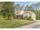 Charming two-story home featuring a stone turret and inviting front porch with driveway at 830 Hightower Trl, Oxford, GA 30054