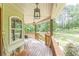 Inviting front porch with wood floors and lantern lighting overlooking manicured lawn at 830 Hightower Trl, Oxford, GA 30054