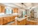 Sunlit kitchen with cooktop island, wood cabinets and adjacent dining area at 830 Hightower Trl, Oxford, GA 30054