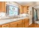 Kitchen sink and countertops with wood cabinets, tile backsplash, and window at 830 Hightower Trl, Oxford, GA 30054
