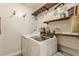 Functional laundry room with modern appliances, rustic shelving, and decorative accents at 830 Hightower Trl, Oxford, GA 30054