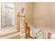 Bright staircase with wood railings and access to the laundry room with decorative tile flooring at 830 Hightower Trl, Oxford, GA 30054