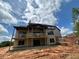 Back view of home with deck under construction and partially wooded lot at 1089 Mount Carmel Church Ln, Canton, GA 30114