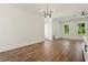 Open-concept living space with modern chandelier, wood floors, and view of bathroom at 2150 Tidwell Ln # 5, Atlanta, GA 30318