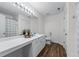 Bathroom with double sinks, white cabinets, a large mirror, and wood-look floors at 3134 Milloak Ct, Buford, GA 30519
