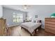 Bedroom featuring wood floors, neutral walls, large window, ceiling fan, and dresser at 3134 Milloak Ct, Buford, GA 30519