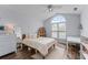 Bright bedroom featuring wood floors, ceiling fan, a large window, and light, neutral walls at 3134 Milloak Ct, Buford, GA 30519