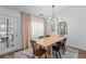 Bright dining room with an adjacent door to the outside patio and a modern chandelier above the dining table at 3134 Milloak Ct, Buford, GA 30519