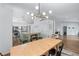 Open-concept kitchen and dining area with a large granite island, modern appliances, and wood dining table at 3134 Milloak Ct, Buford, GA 30519