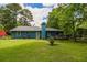Beautiful single-Gathering home with lush green lawn, deck, and a chimney, set against a backdrop of mature trees and blue skies at 3739 Lake Carlton Rd, Loganville, GA 30052