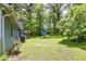 Spacious backyard with lush green grass, mature trees, and a charming shed, creating a serene and private outdoor space at 3739 Lake Carlton Rd, Loganville, GA 30052
