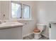 Functional bathroom featuring a vanity, toilet, and window, providing convenience and natural light at 3739 Lake Carlton Rd, Loganville, GA 30052