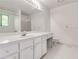Well-lit bathroom features a large vanity, a spacious mirror, and tiled floors, offering a clean and functional space at 3739 Lake Carlton Rd, Loganville, GA 30052