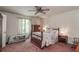 Cozy bedroom with a floral-themed bedspread, soft carpet, and natural light at 3739 Lake Carlton Rd, Loganville, GA 30052