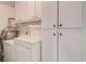 Functional laundry room with a washer, a dryer, and storage cabinets, maximizing efficiency and organization at 3739 Lake Carlton Rd, Loganville, GA 30052