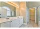 Bright bathroom featuring double sinks, a large mirror, and a walk-in closet at 1016 E Bay Springs Dr, Villa Rica, GA 30180