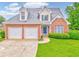 Charming brick home featuring a two-car garage, well-maintained lawn, and inviting blue front door at 1016 E Bay Springs Dr, Villa Rica, GA 30180