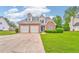 Beautiful brick front exterior featuring a well-manicured lawn, two-car garage, and classic design at 1016 E Bay Springs Dr, Villa Rica, GA 30180