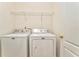 Convenient laundry room with white appliances and shelving for storage at 1016 E Bay Springs Dr, Villa Rica, GA 30180