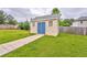 Outdoor shed with a light exterior, blue door, and pathway surrounded by a green lawn at 1016 E Bay Springs Dr, Villa Rica, GA 30180