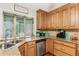 Well-lit kitchen featuring granite countertops, stainless steel dishwasher, and wooden cabinetry at 1359 Cedar Park Pl, Stone Mountain, GA 30083