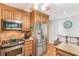 Modern kitchen with stainless steel appliances, granite countertops, wood cabinets, and a gas range at 1359 Cedar Park Pl, Stone Mountain, GA 30083