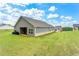 Back view of home with covered patio and large grassy yard at 426 Samara Ct, Fairburn, GA 30213