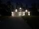 Inviting single-story home with stone accents, a well-lit driveway, and manicured landscaping at nighttime at 426 Samara Ct, Fairburn, GA 30213