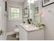 Clean bathroom with granite countertop, white vanity, and framed pictures at 569 Woods Nw Dr, Atlanta, GA 30318
