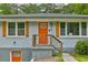 This house features orange shutters and an orange door with matching orange trim for basement door at 569 Woods Nw Dr, Atlanta, GA 30318
