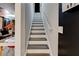 Straight stairway between floors with a white handrail, with a glimpse of a room at the bottom at 569 Woods Nw Dr, Atlanta, GA 30318