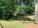 Well-maintained backyard featuring green grass, mature trees, and a partial view of the neighboring houses at 615 Barrington Way, Roswell, GA 30076
