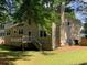 Spacious backyard with a deck, green lawn, and mature trees, providing a serene outdoor space at 615 Barrington Way, Roswell, GA 30076