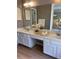 Bathroom featuring a double sink vanity and a mirror reflecting the bedroom beyond at 615 Barrington Way, Roswell, GA 30076
