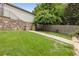 A manicured lawn and stone pathway lead through the green backyard with tiered retaining wall and garden at 101 Terrace Dr, Atlanta, GA 30305