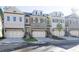Row of modern townhomes with neutral brick, multi-car garages, dormer windows, and well-manicured landscaping at 2270 Siskin Square Rd # 91, Duluth, GA 30096