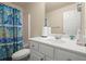 Well-lit bathroom with blue patterned shower curtain, white vanity, and neutral walls at 2755 Greenbridge Dr, Norcross, GA 30071