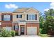 Charming townhouse with brick and beige siding, complemented by black shutters and a single car garage at 2755 Greenbridge Dr, Norcross, GA 30071