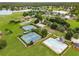 Community aerial view highlighting tennis courts, swimming pool, playground, and lush greenery near a scenic lake at 5917 Southland Dr, Stone Mountain, GA 30087