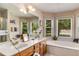 Bright bathroom featuring double sinks, a soaking tub, and large windows at 5917 Southland Dr, Stone Mountain, GA 30087