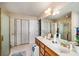 Well-lit bathroom featuring a double vanity, tiled floors, and a glass shower at 5917 Southland Dr, Stone Mountain, GA 30087