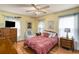 Comfortable bedroom with a double bed, ceiling fan, windows and wood flooring at 5917 Southland Dr, Stone Mountain, GA 30087
