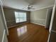 Bright bedroom with hardwood floors, a ceiling fan, and a large window overlooking the yard at 1167 Drewsbury Ct, Smyrna, GA 30080