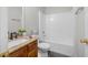 Bathroom featuring a vanity with granite countertop and wood cabinets, plus a white tub and shower combination at 1439 Alice Ave, Lithonia, GA 30058