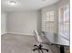 Bright bedroom featuring large windows, neutral carpet, and a functional desk area at 1439 Alice Ave, Lithonia, GA 30058