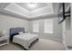 Bedroom features a tray ceiling, two windows with blinds, and a wall-mounted television at 1439 Alice Ave, Lithonia, GA 30058