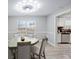 Dining room area featuring unique modern light fixture, wood floors, and open to the kitchen at 1439 Alice Ave, Lithonia, GA 30058