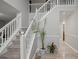 Inviting foyer features hardwood flooring, staircase with white railing and a plant at 1439 Alice Ave, Lithonia, GA 30058
