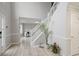 Welcoming home foyer with wood floors, white staircase and plants at 1439 Alice Ave, Lithonia, GA 30058